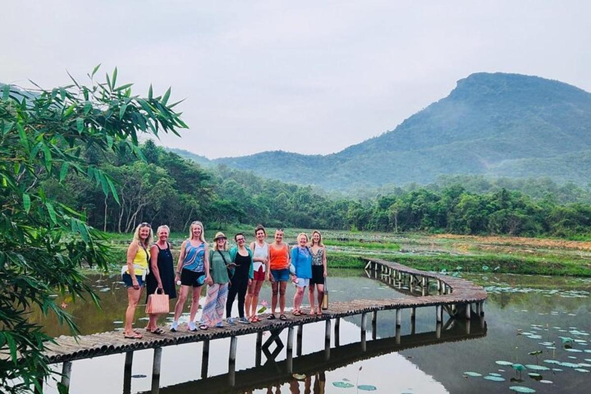 sekelompok wanita berdiri di jembatan di atas sungai