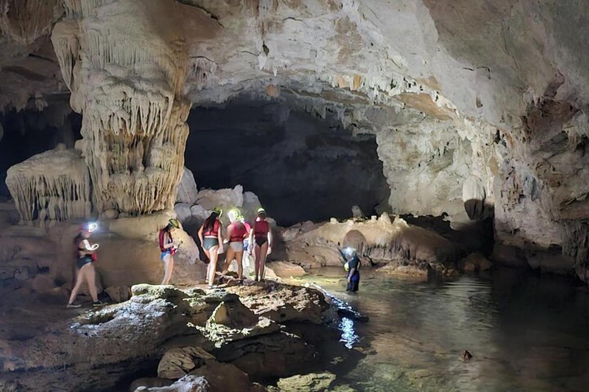 a group of people standing in the water in a cave