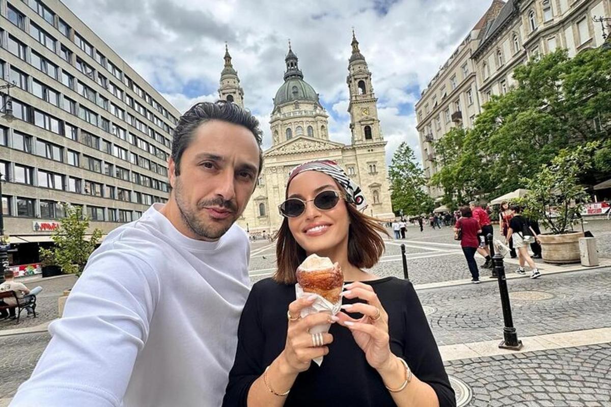 um homem e uma mulher comendo comida em uma cidade