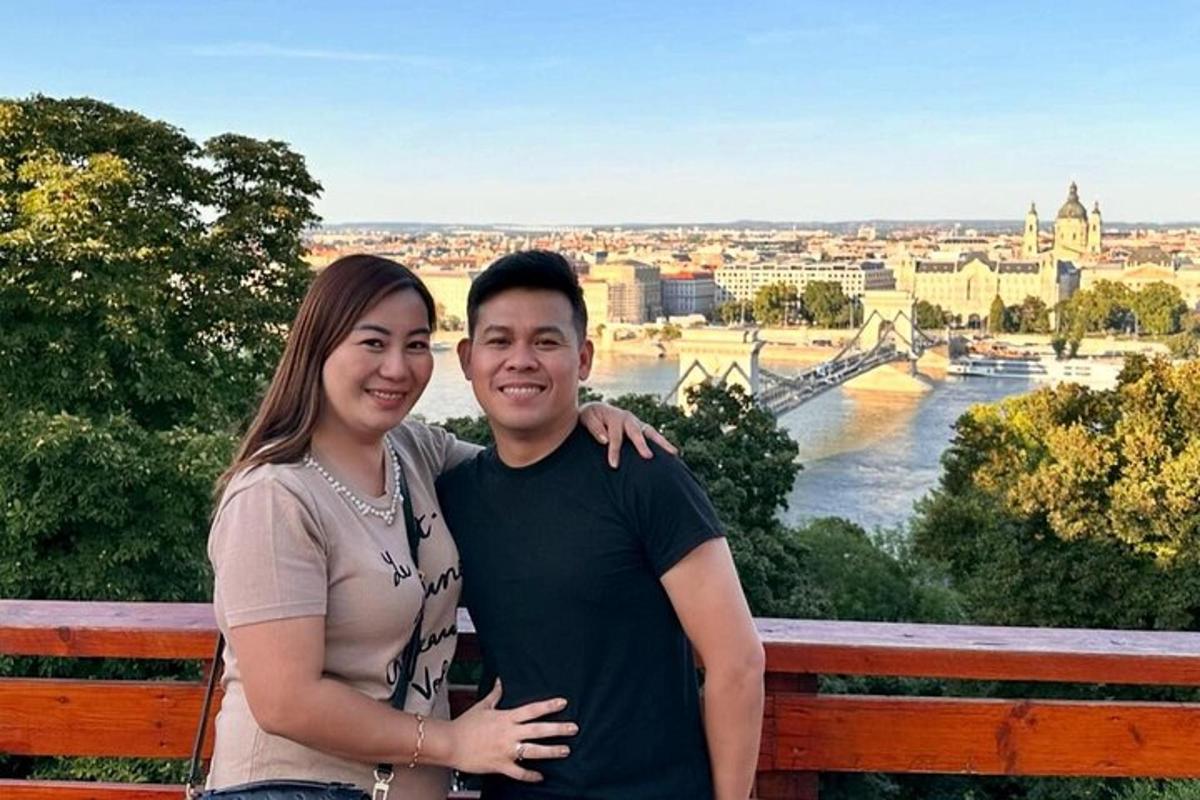 um homem e uma mulher em pé em um banco com vista para uma cidade