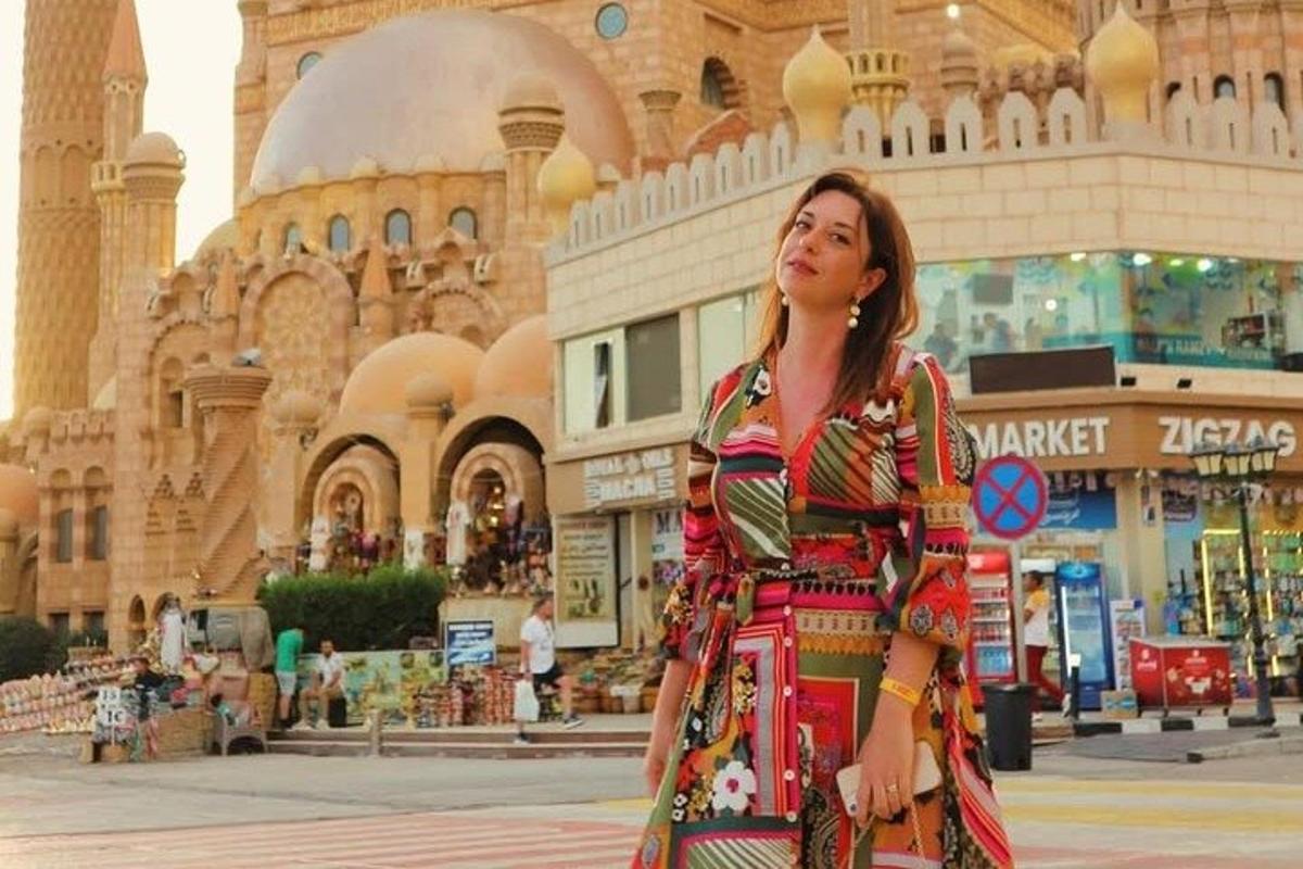 امرأة ترتدي فستانًا تقف أمام مبنى