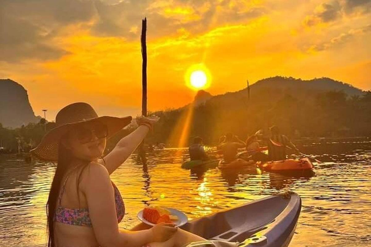 uma garota em um barco na água ao pôr do sol
