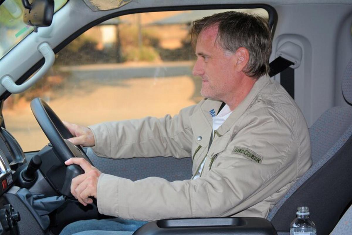 a man driving a car while holding a steering wheel
