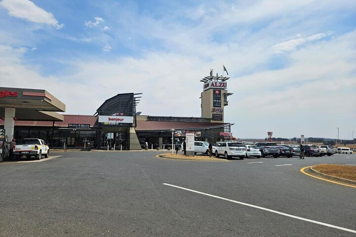 a parking lot with cars parked in front of a gas station