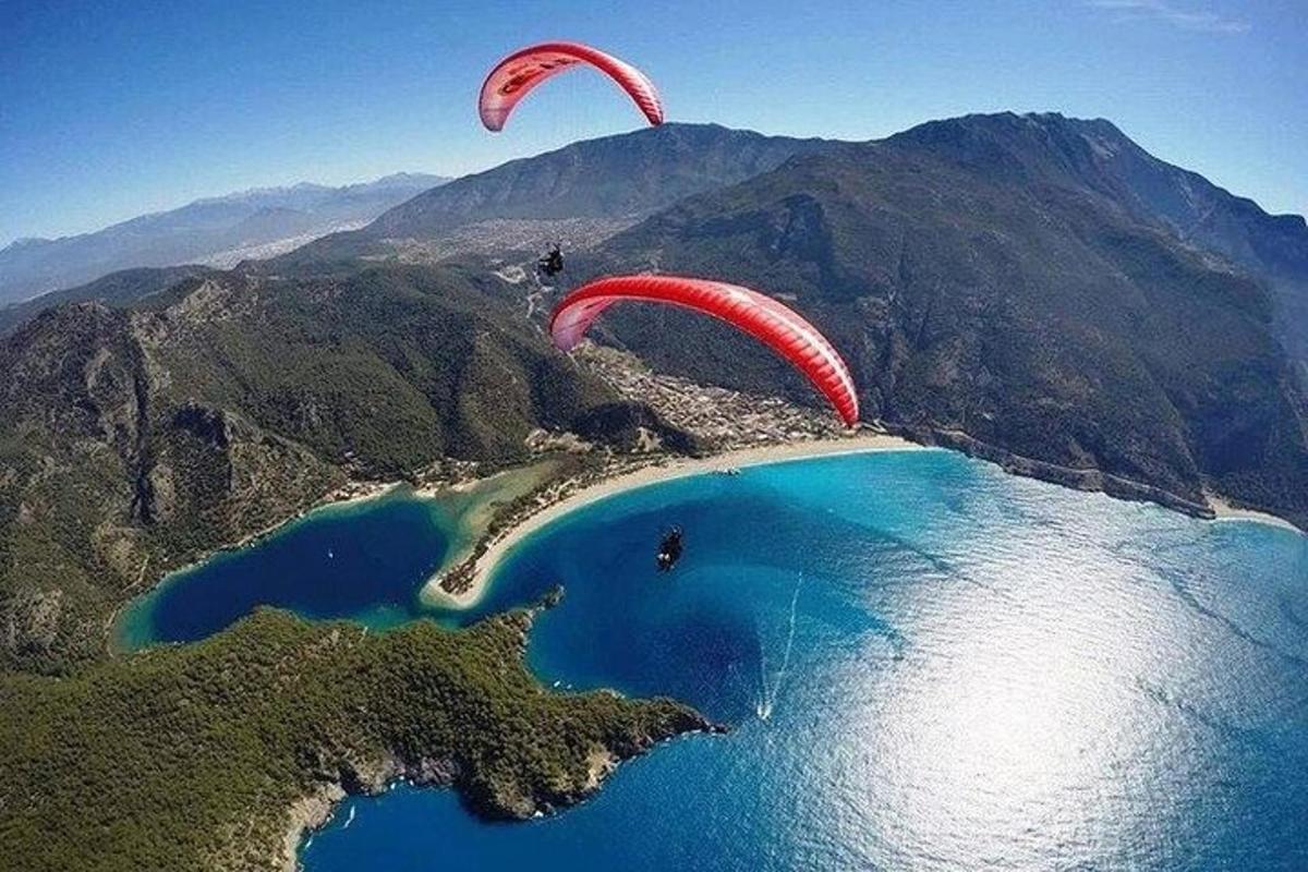 Dva paraglidisti létají nad jezerem