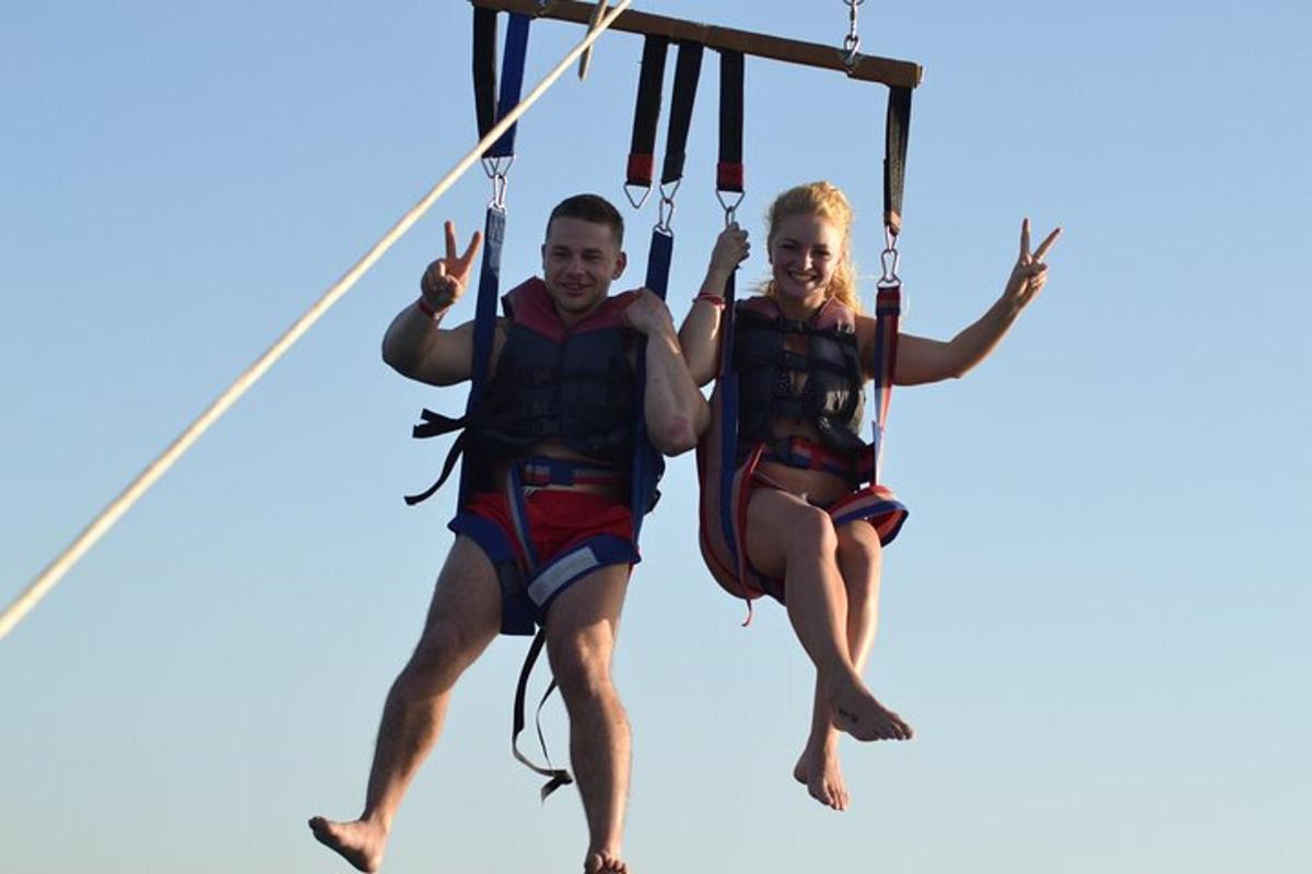 isang lalaki at isang babae na nakasakay sa isang zip line
