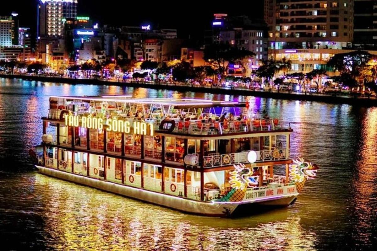 Un barco en un río con una ciudad de noche.