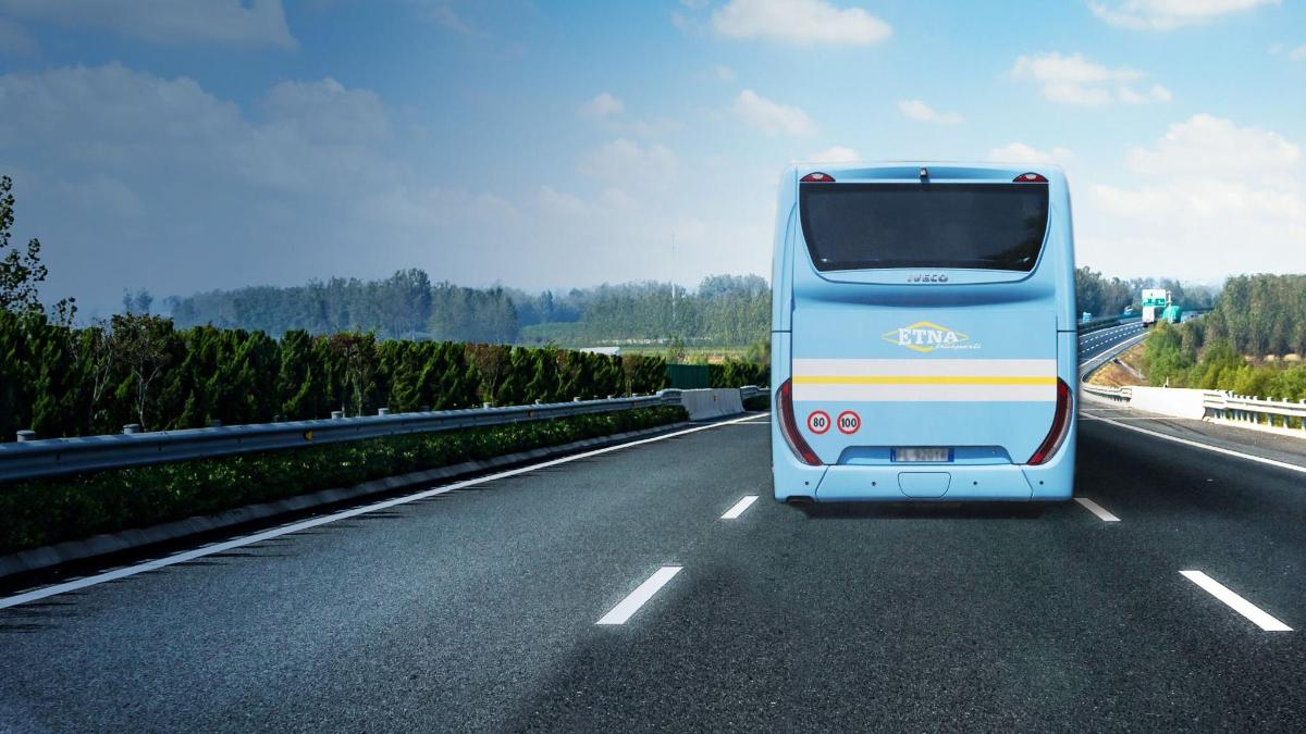 Un autobús azul circula por la autopista.