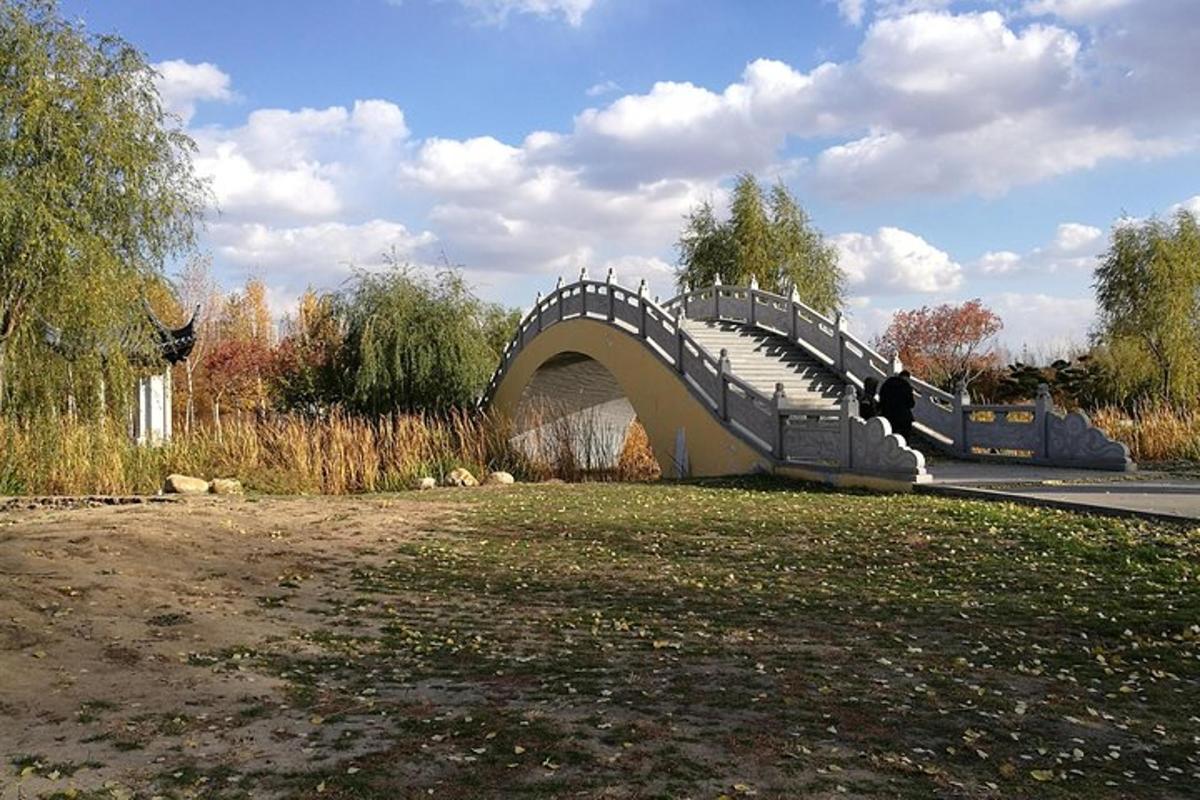 a person sitting on a bridge over a body of water