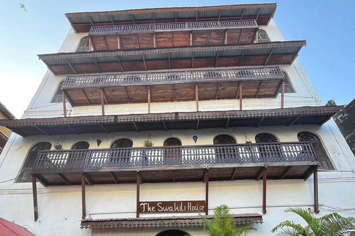 een hoog gebouw met balkons en een bord erop