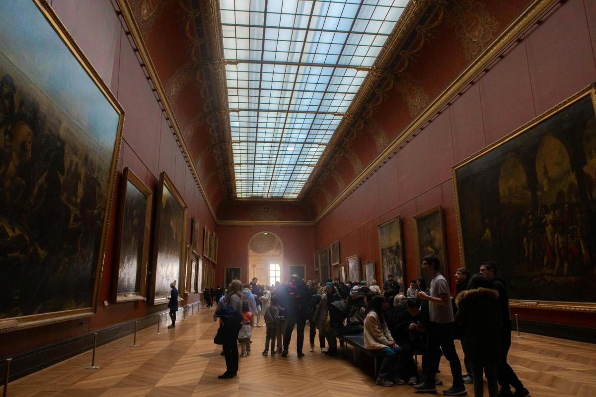 una multitud de gent en un museu amb quadres