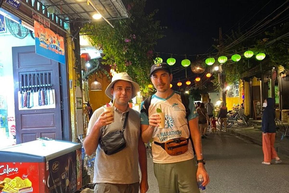dua pria berdiri di jalan sambil makan pisang