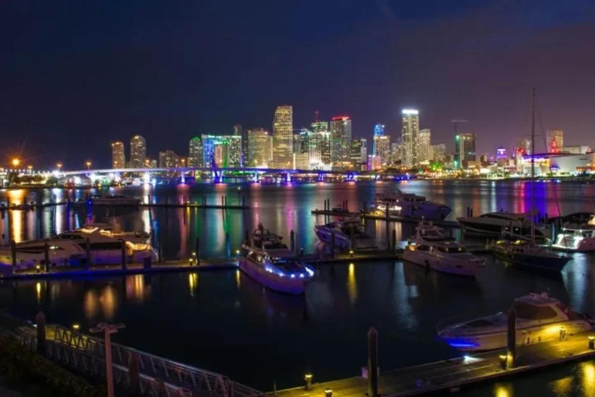 a city skyline at night with boats in the water
