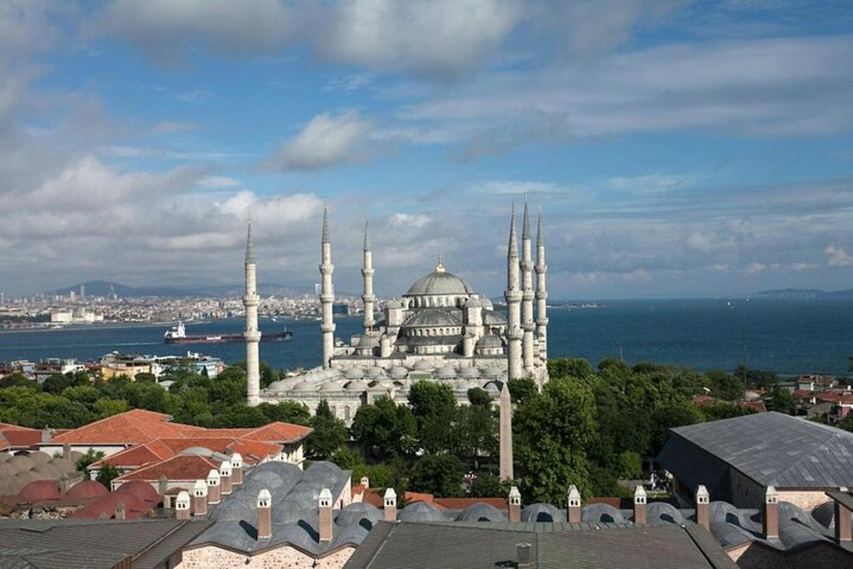 a large white building with mosques in a city