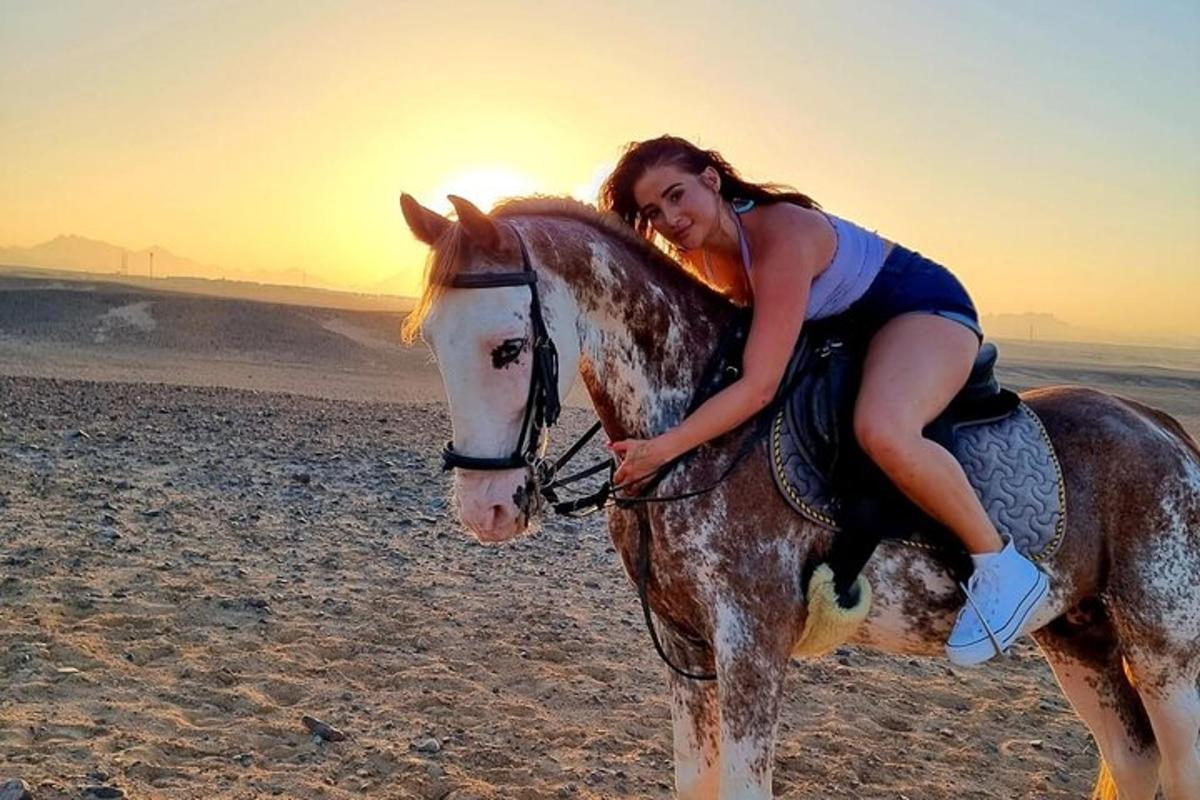 una donna a cavallo sulla spiaggia