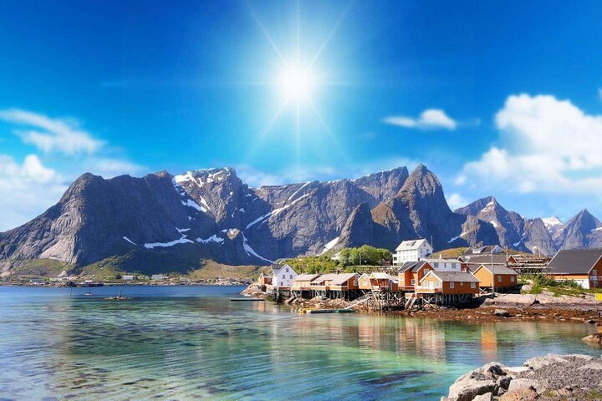 a town on the water with mountains in the background
