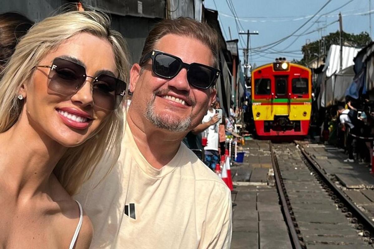 un bărbat și o femeie stând în fața unui tren