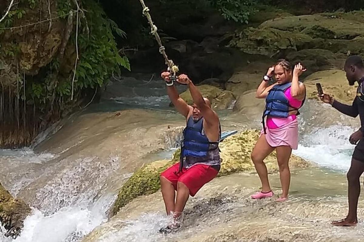 um grupo de pessoas em um balanço de corda em um rio