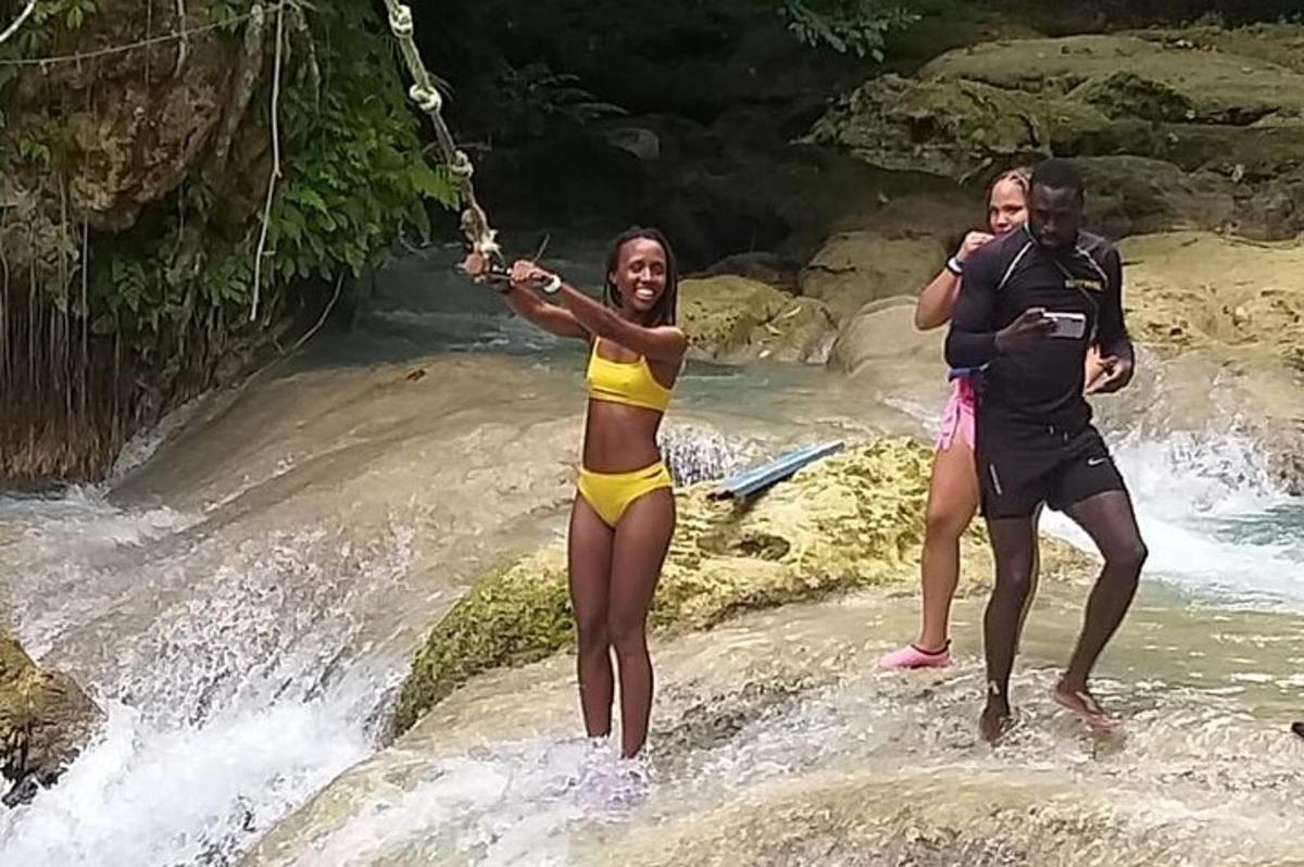 um grupo de pessoas em pé sobre pedras em um rio