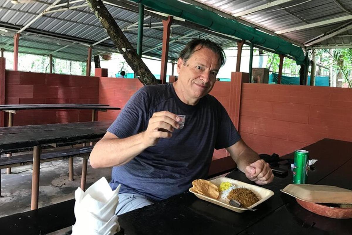 seorang pria duduk di meja dengan sepiring makanan