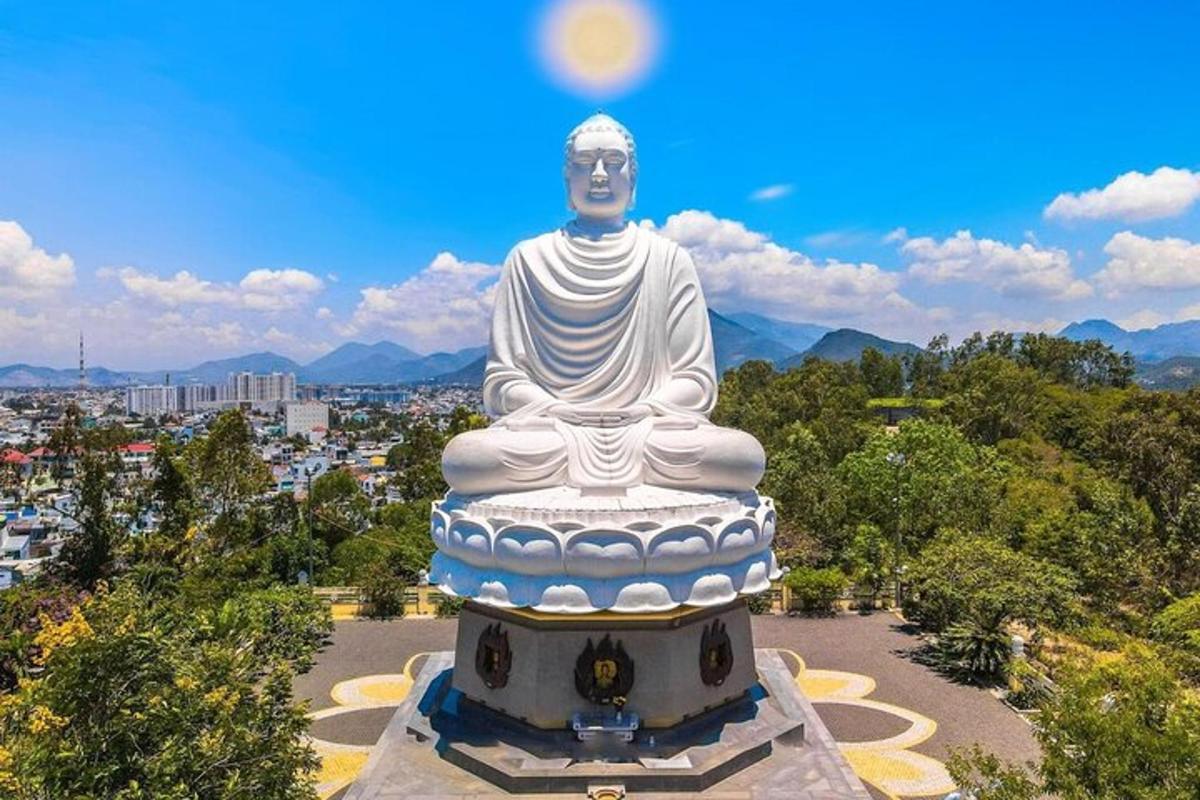 una grande statua di un Buddha si trova in un parco