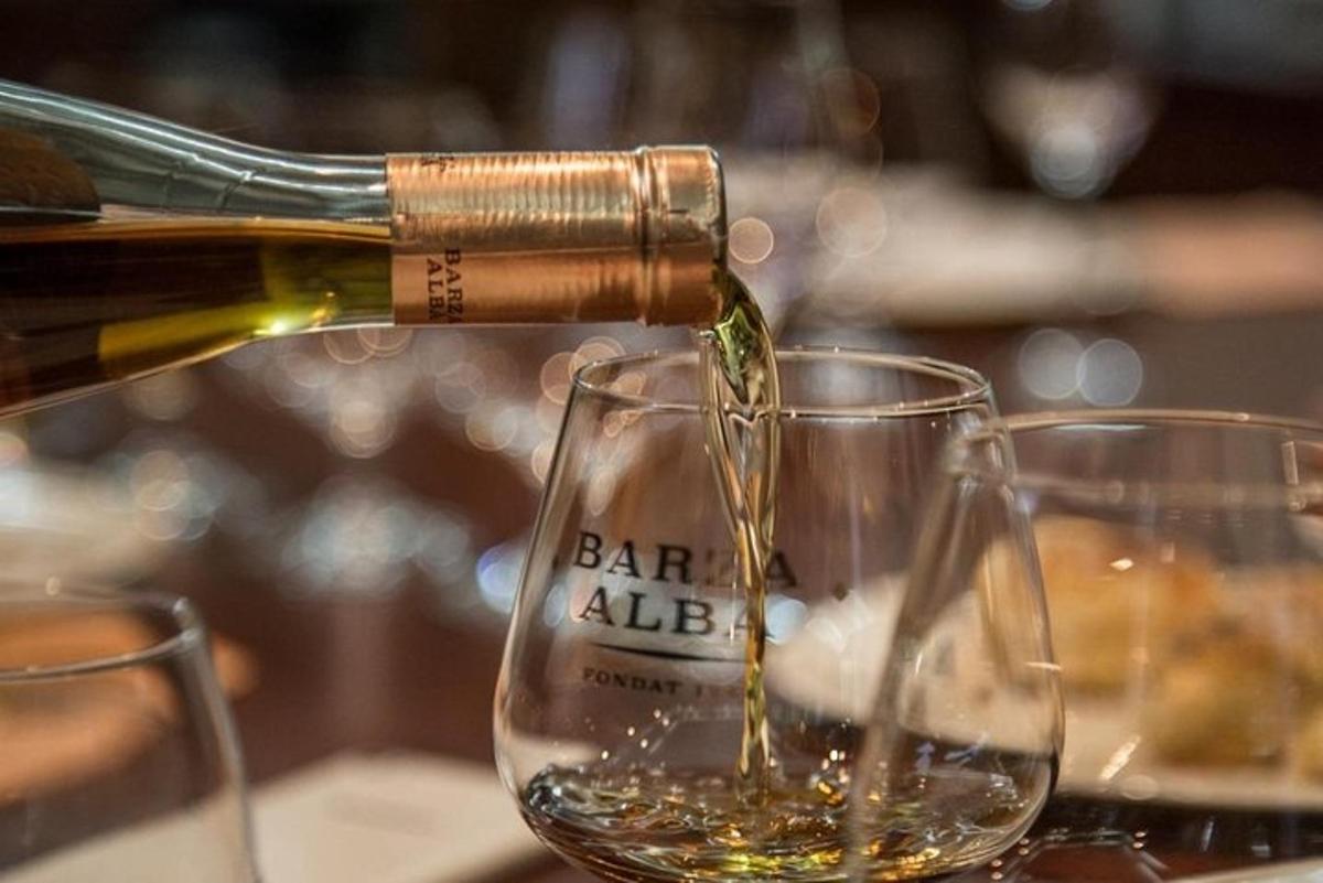 a bottle of wine being poured into two wine glasses