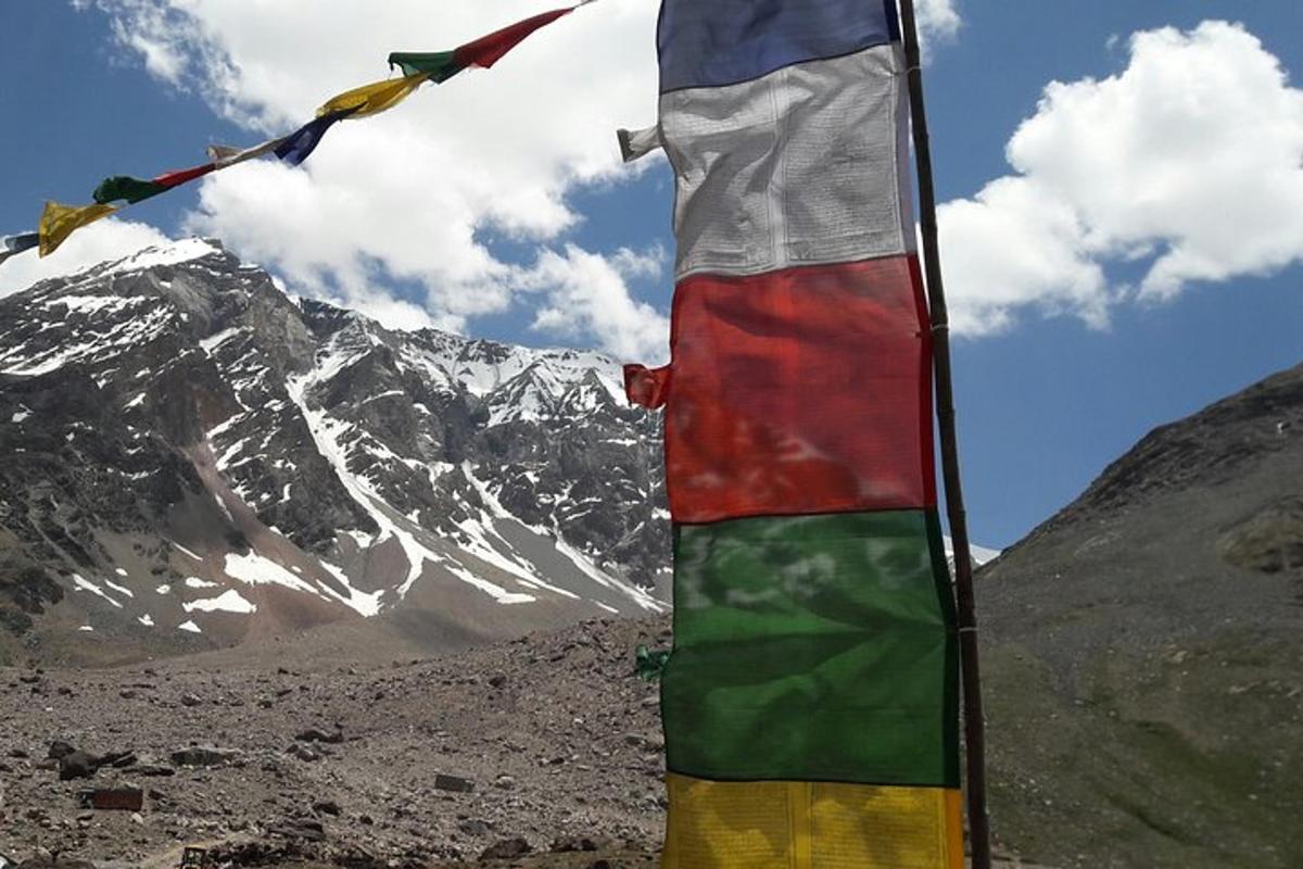 a flag with prayer flags in front of a mountain