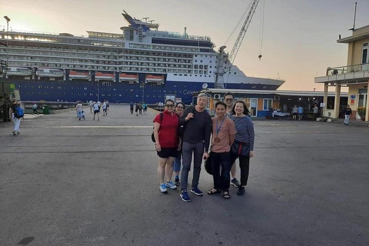 un gruppo di persone in piedi davanti a una nave da crociera