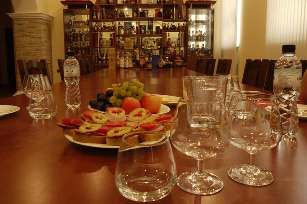 a table with wine glasses and a plate of fruit