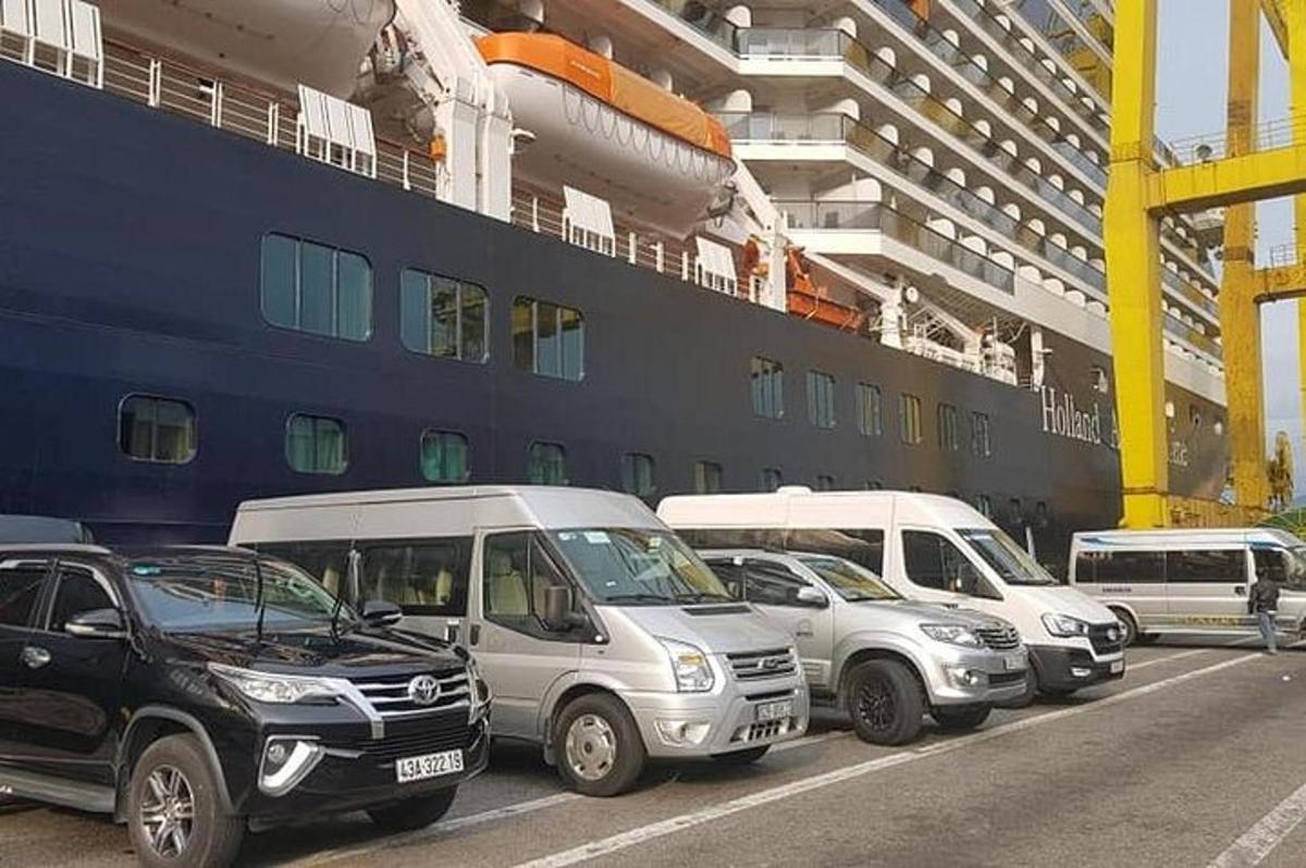 um grupo de carros estacionados ao lado de um navio de cruzeiro