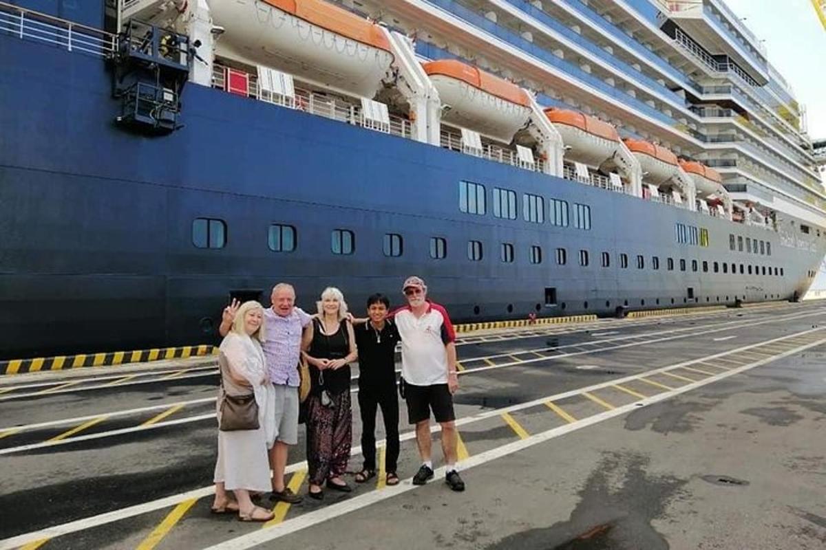 un gruppo di persone in piedi davanti a una nave da crociera