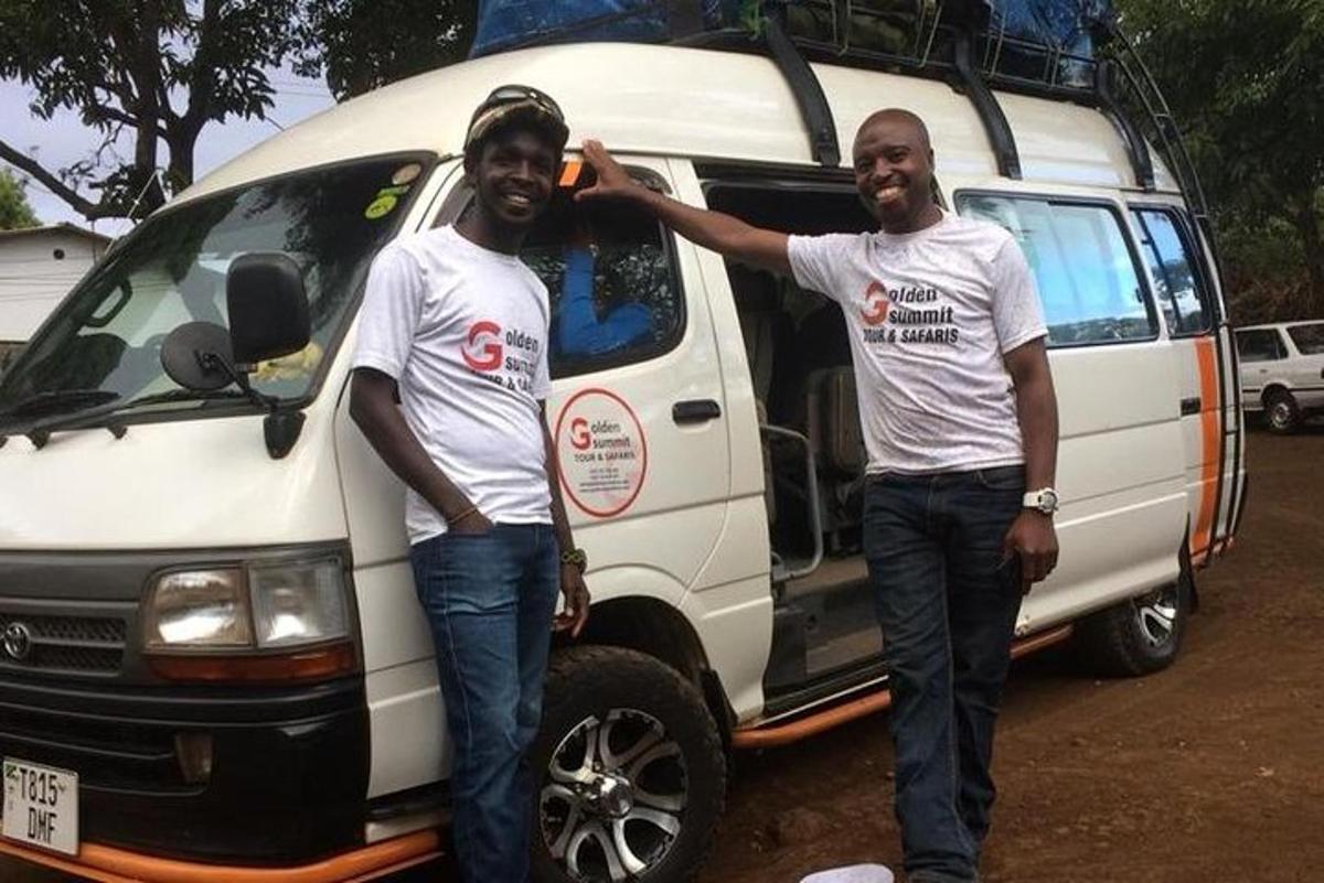 two men standing in front of a white van