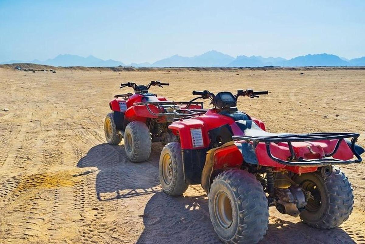 two atvs parked in the sand in the desert
