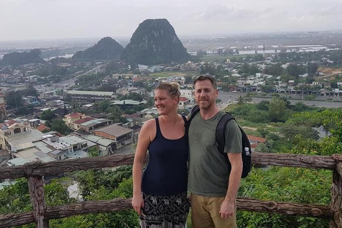 een man en een vrouw staan op de top van een berg