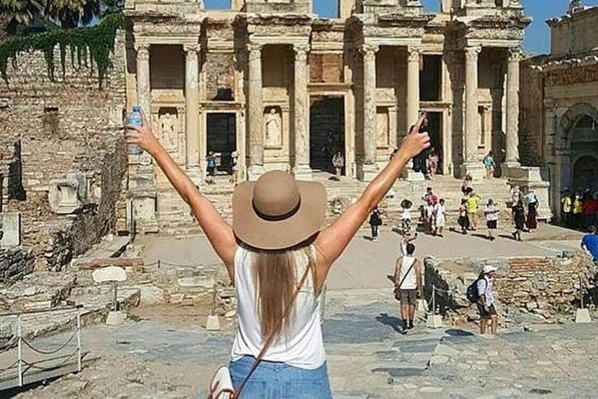şapkalı bir kadın kalıntıların önünde fotoğraf çektiriyor
