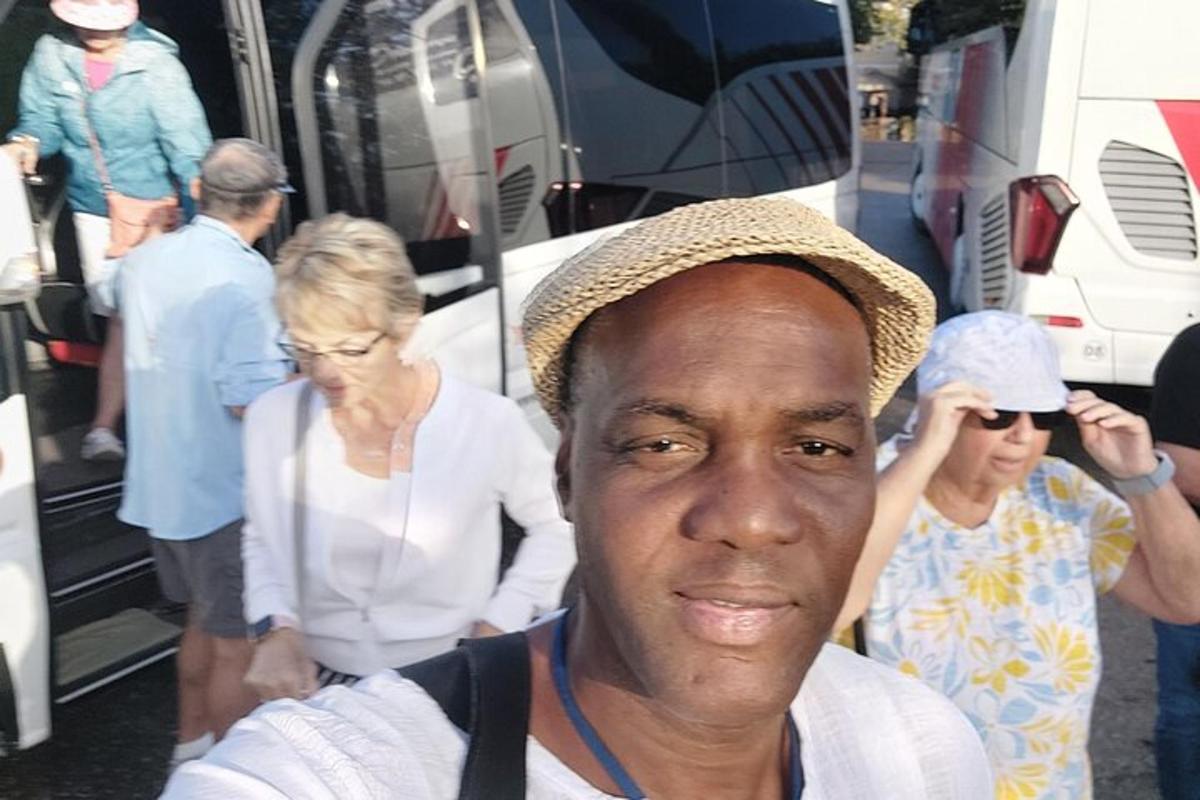 un home amb barret dret davant d'un grup de persones