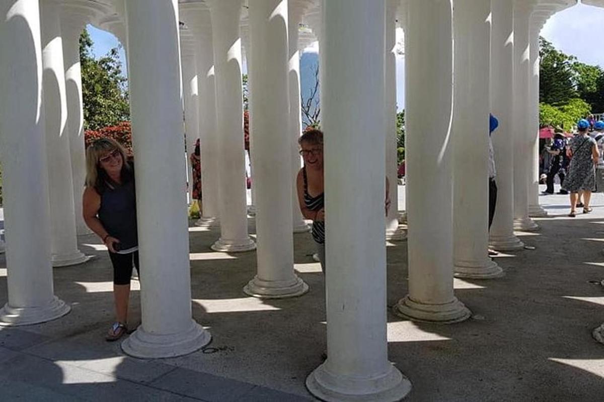 un uomo e una donna in piedi sotto una fila di colonne bianche
