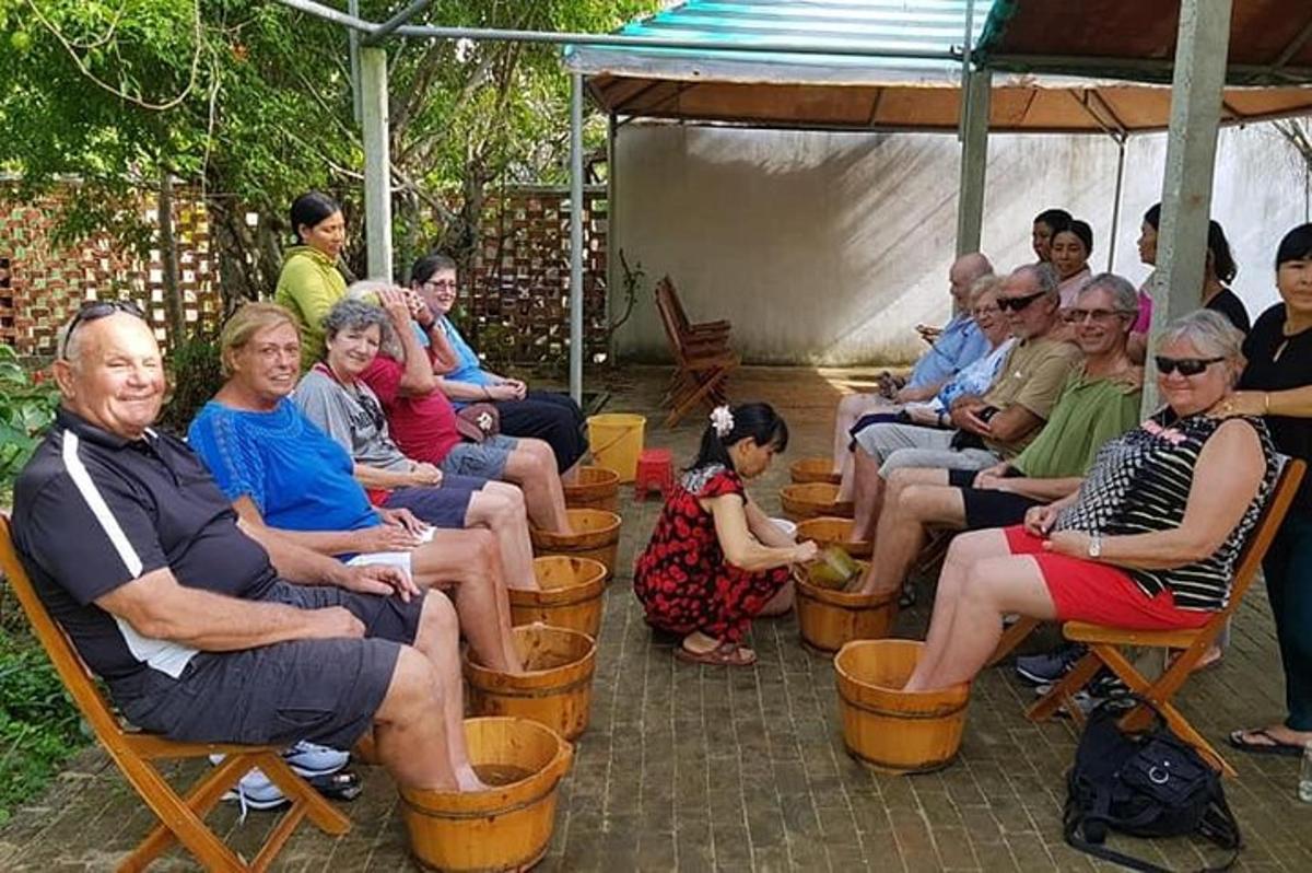 một nhóm người ngồi trên ghế dưới tán cây