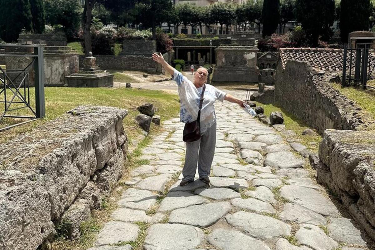 um homem em pé sobre um muro de pedra com os braços estendidos