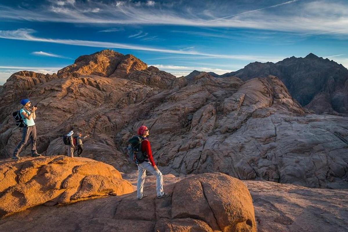 hópur fólks sem stendur uppi á fjallstindi