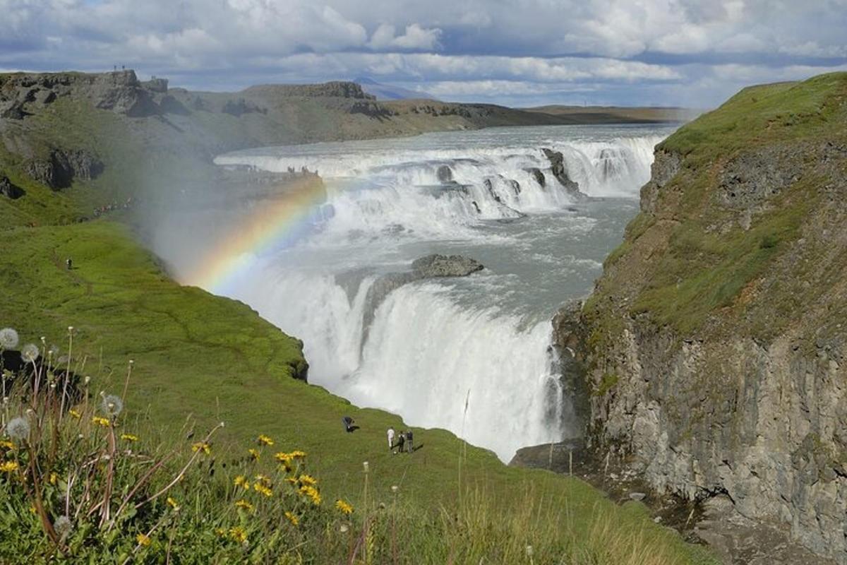 a rainbow at the brink of a waterfall