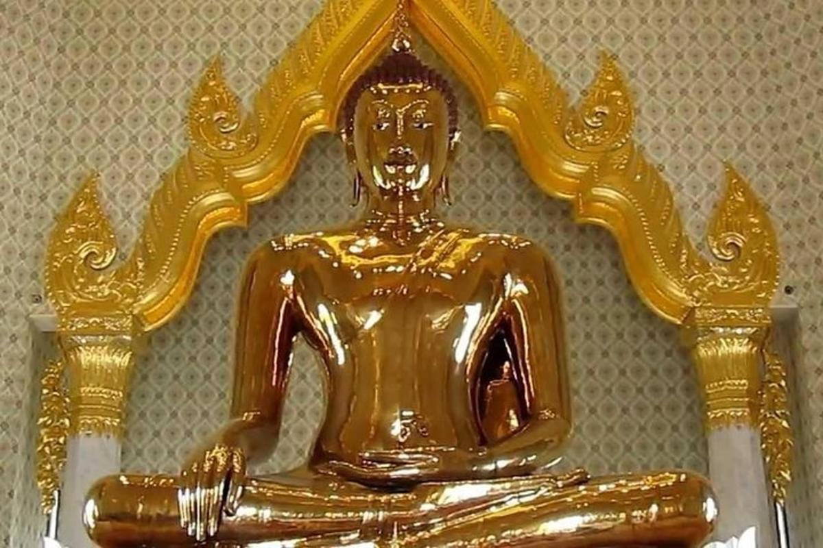 a gold statue of a person sitting on a table