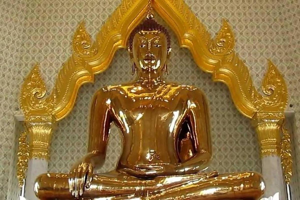 una estàtua de Buda d'or asseguda sobre una taula