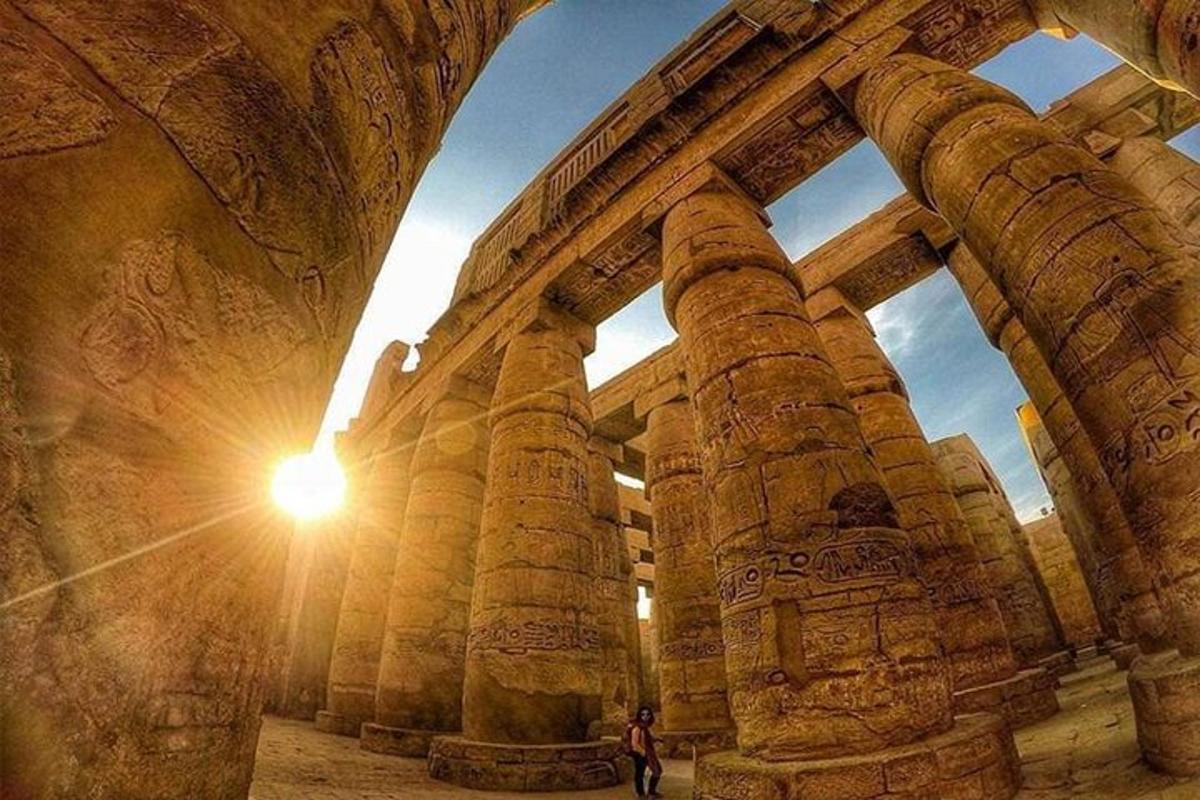 una persona in piedi di fronte a un grande edificio in pietra