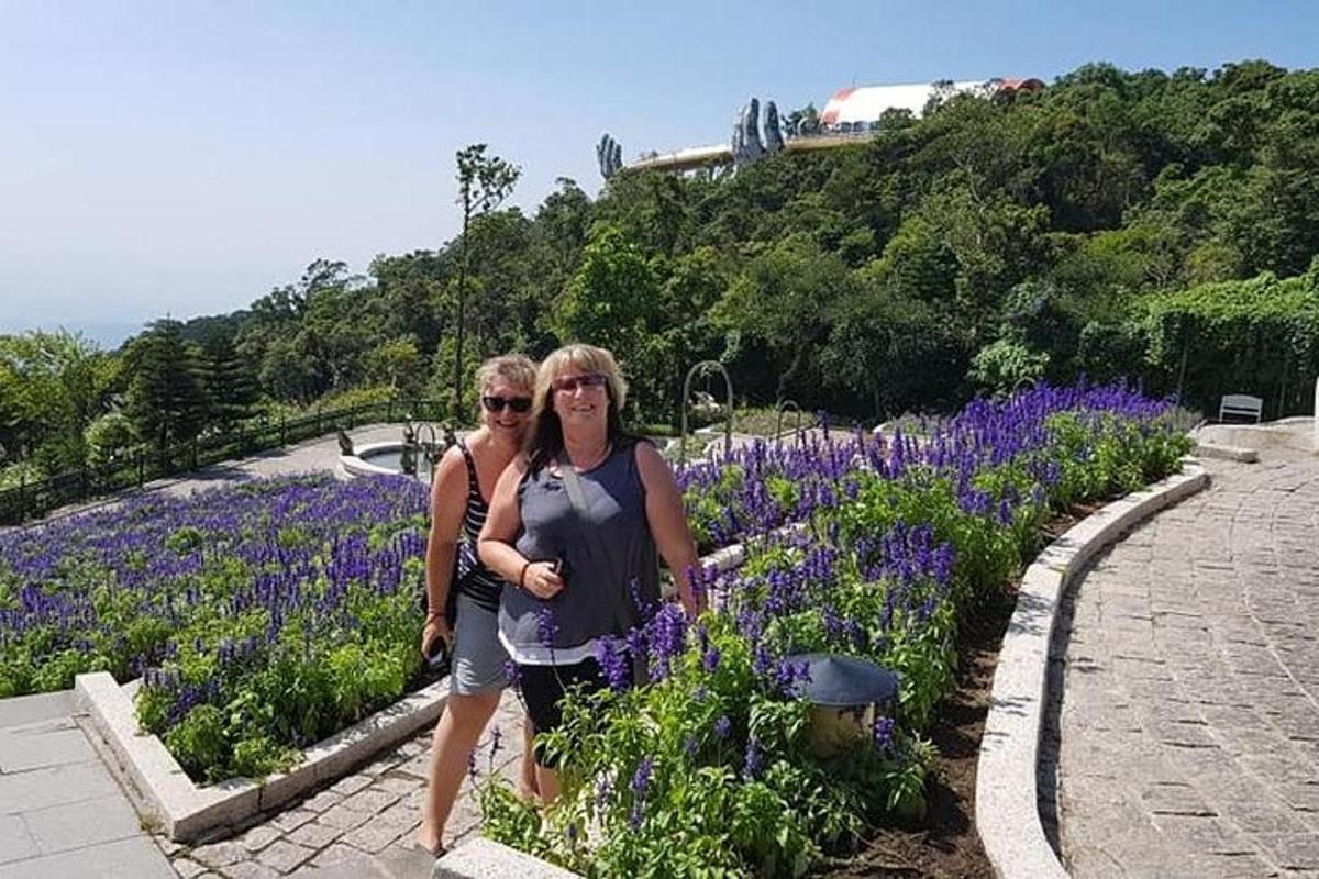 Δύο γυναίκες που στέκονται σε έναν κήπο με μοβ λουλούδια