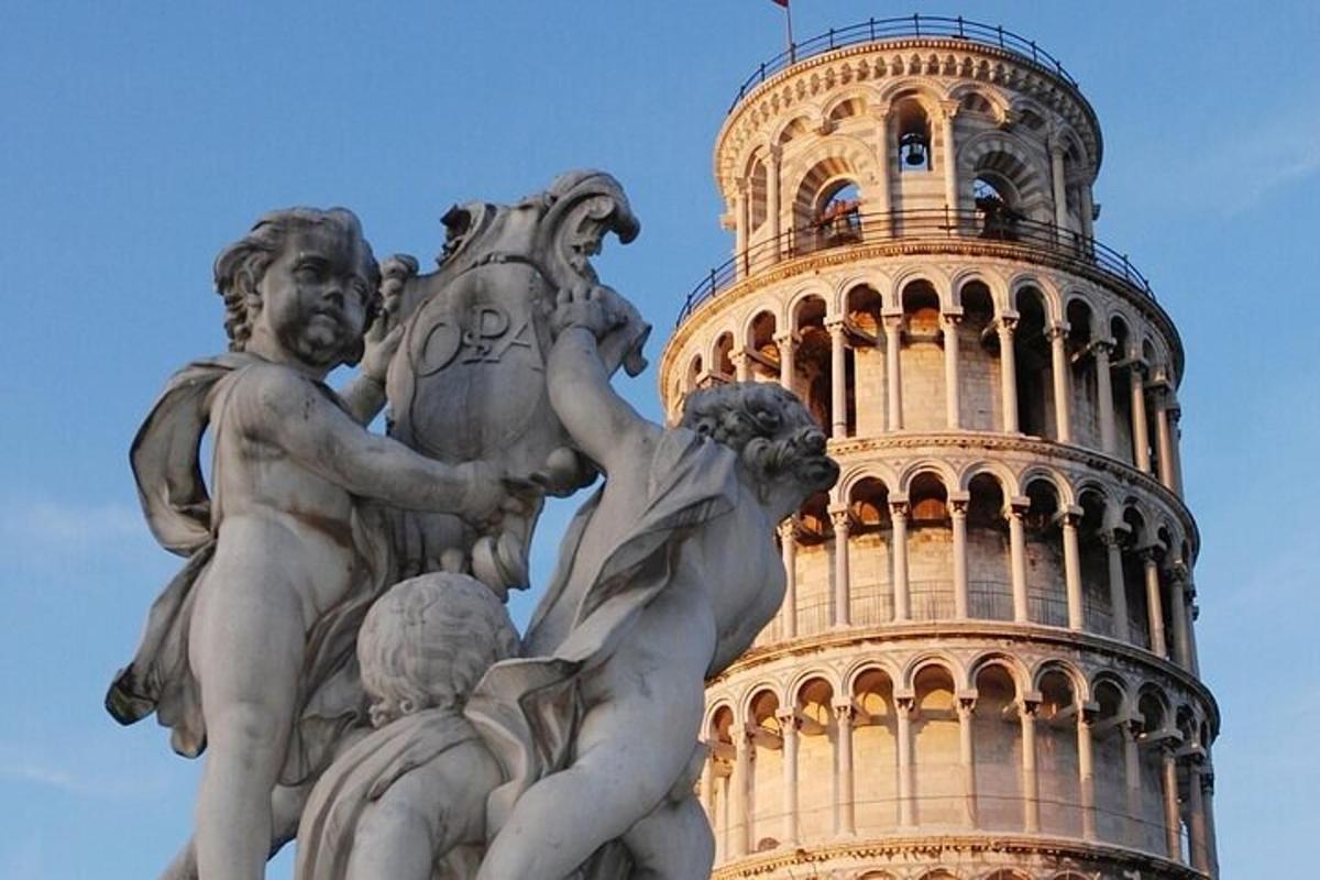 a statue in front of a tower with a building