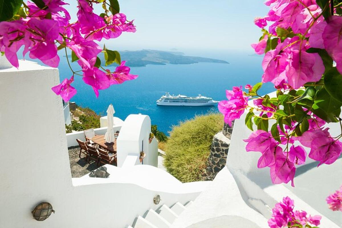 una vista de l'oceà des d'una casa amb flors roses