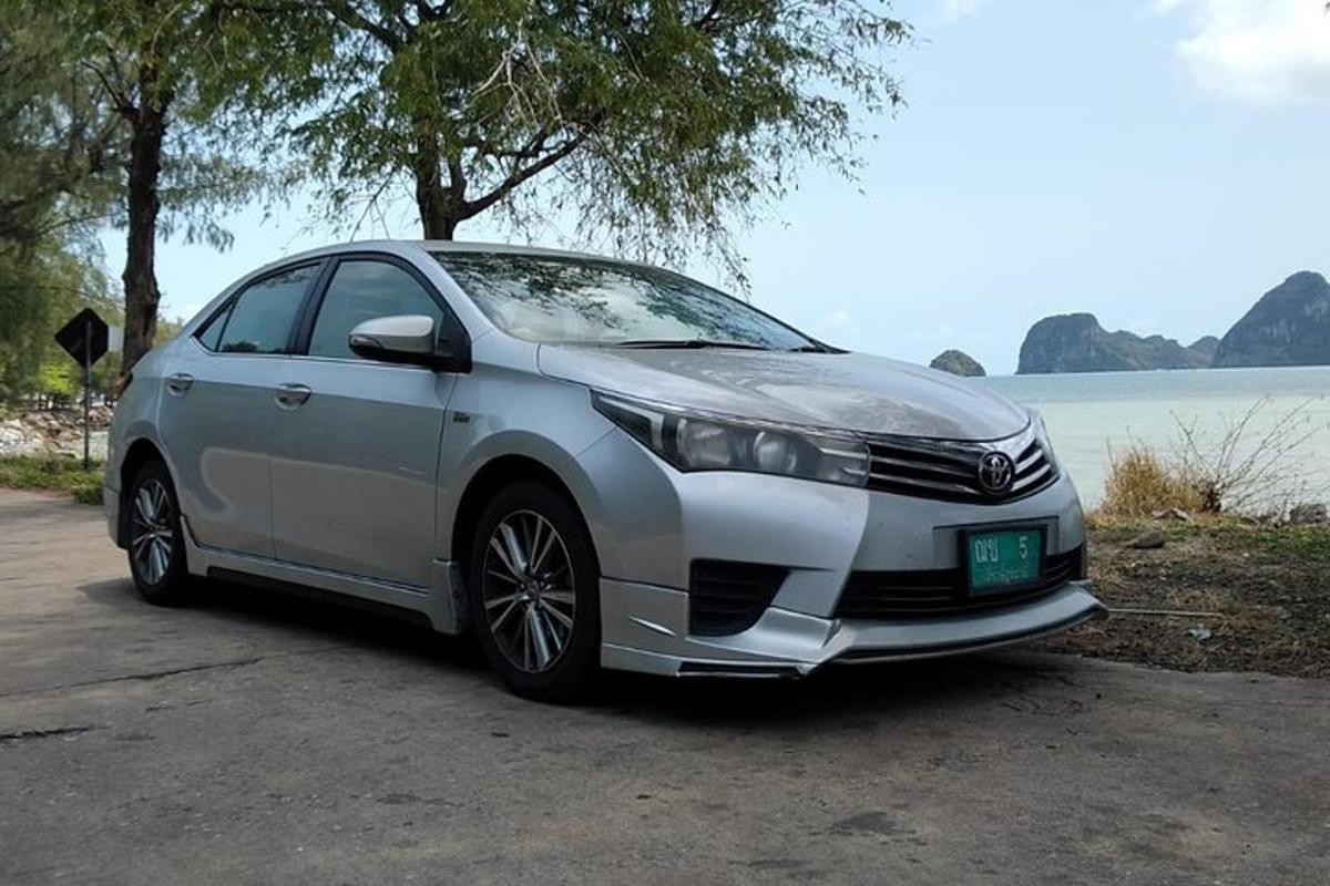 một chiếc xe màu bạc đỗ bên cạnh một vùng nước