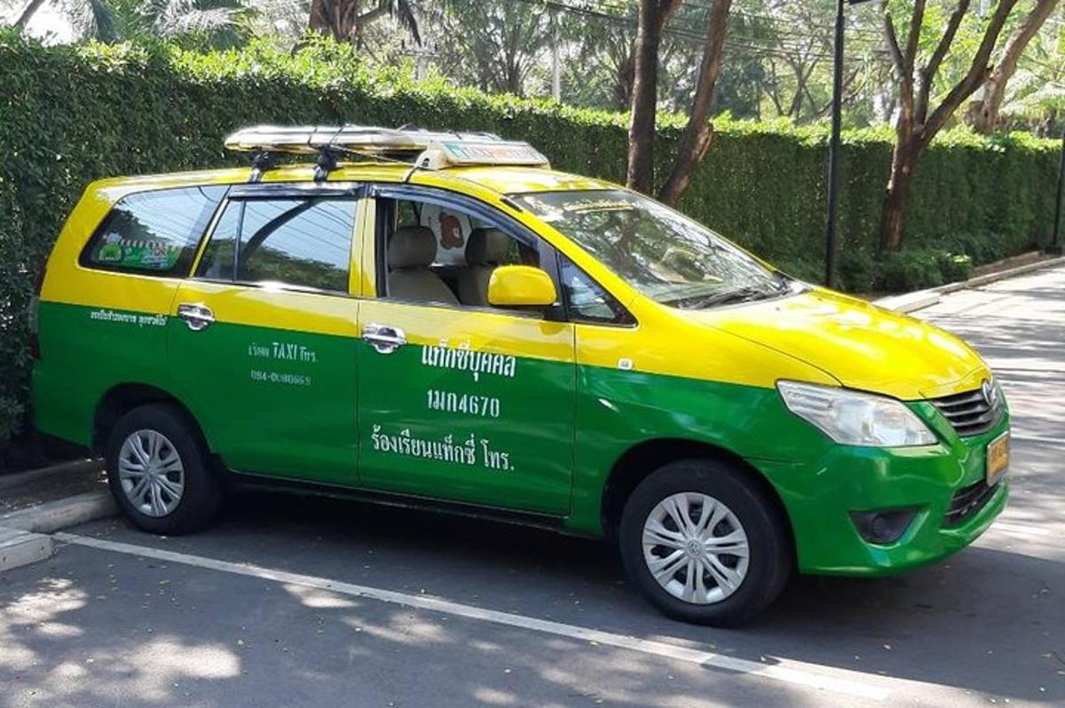một chiếc xe màu xanh lá cây và màu vàng đậu trong bãi đậu xe