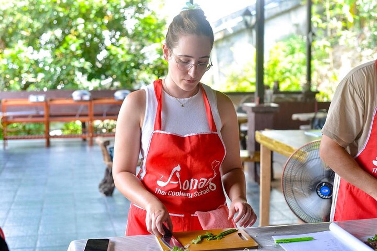 seorang wanita ber apron merah menyediakan makanan di meja